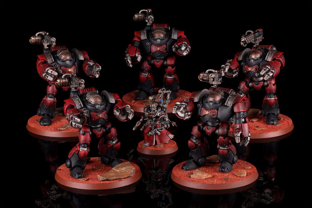 Five red and black Kastelan Robots surround a Cybernetica Datasmith on rust-coloured bases